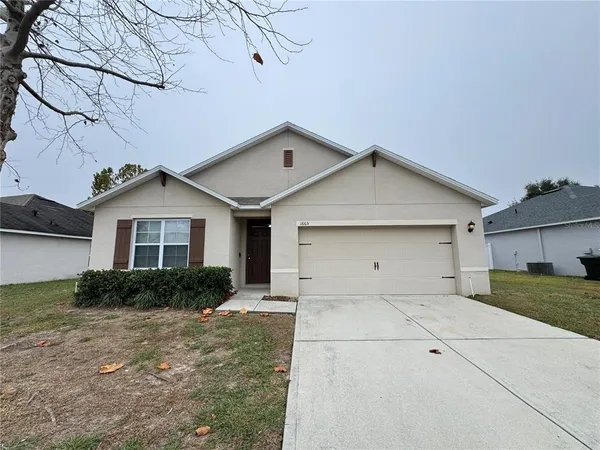 a front view of a house with garage and yard