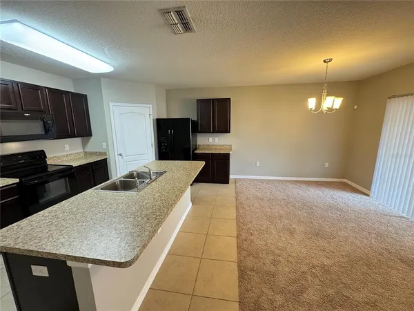 a kitchen with a sink a stove and cabinets