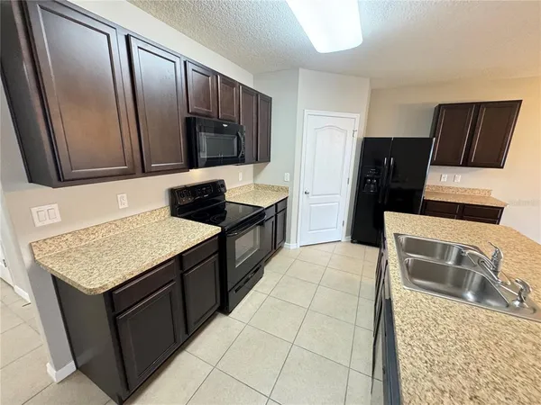 a kitchen with a sink refrigerator and microwave