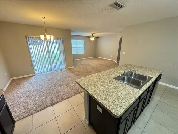 an open kitchen with granite countertop sink and dishwasher