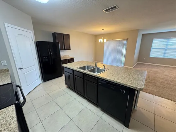 a kitchen with stainless steel appliances granite countertop a sink refrigerator and microwave