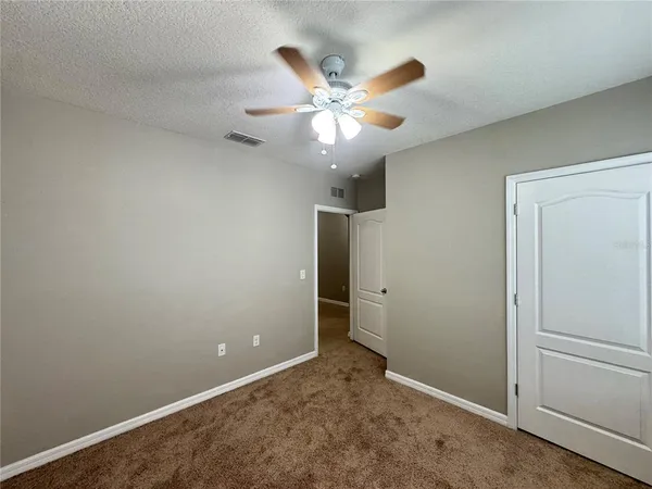 an empty room with closet and windows