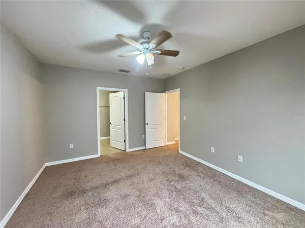 an empty room and chandelier fan
