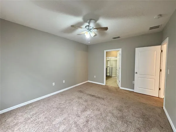 an empty room with closet and a ceiling fan