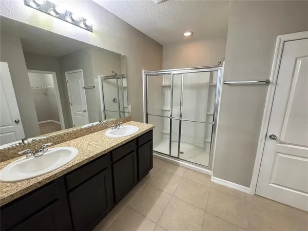 a bathroom with a granite countertop sink mirror and shower