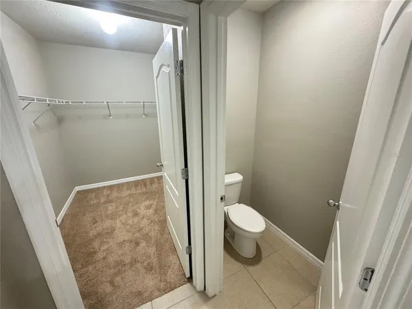 a bathroom with a granite countertop shower and a toilet