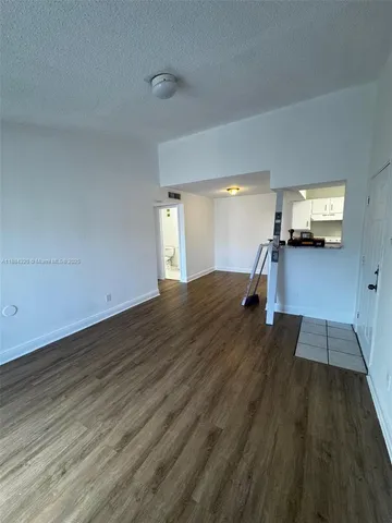 a view of a living room hardwood floor and a kitchen