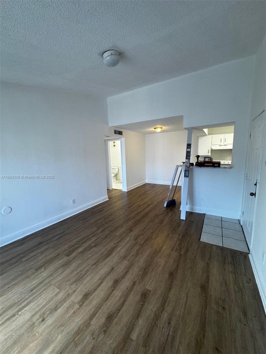 15040 Southwest 103rd Lane, Unit 3202 Miami, FL 33196 - Photo 2 of 14 a view of a living room hardwood floor and a kitchen