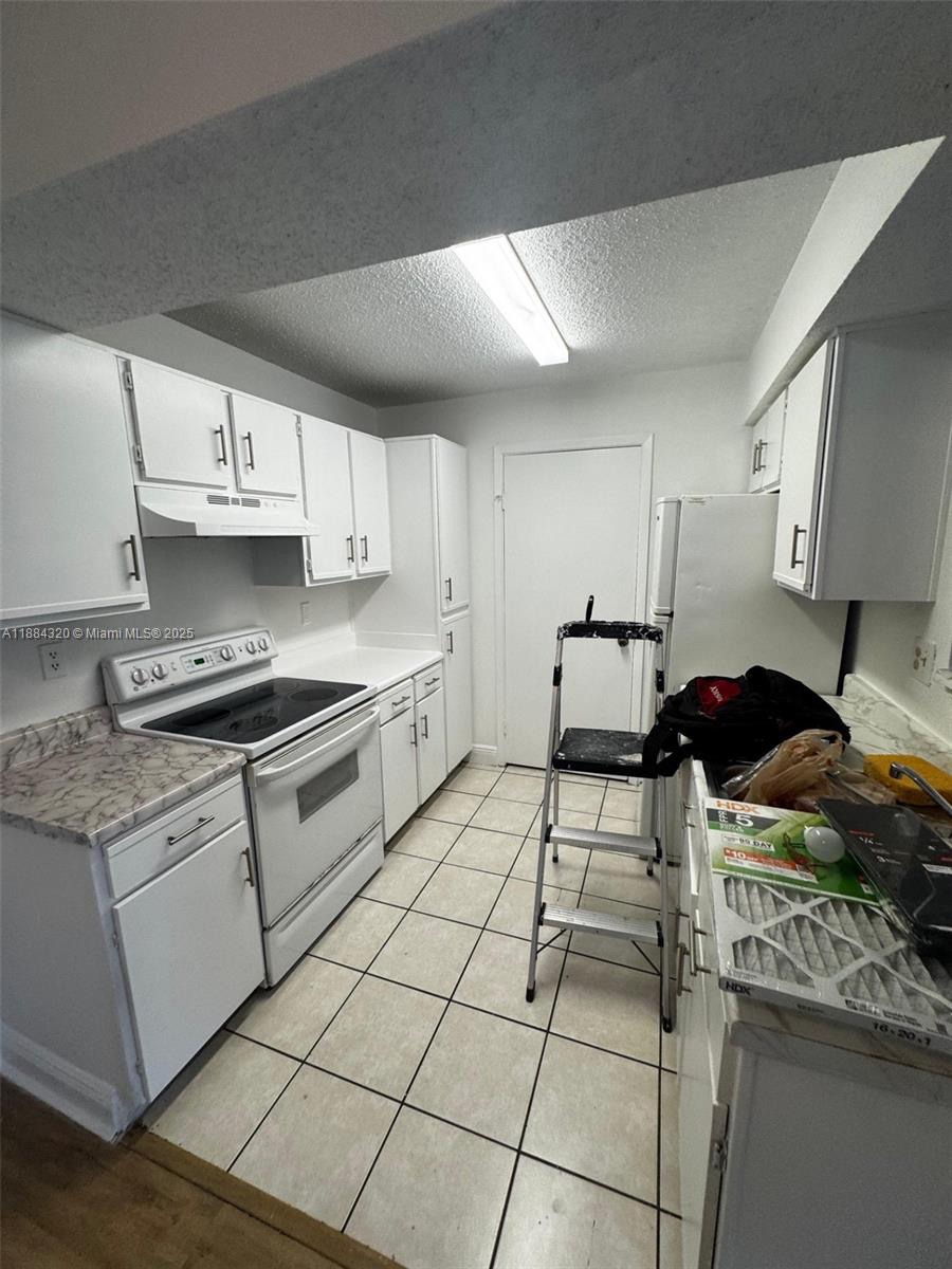 15040 Southwest 103rd Lane, Unit 3202 Miami, FL 33196 - Photo 6 of 14 a kitchen with stainless steel appliances granite countertop a stove a sink and a refrigerator