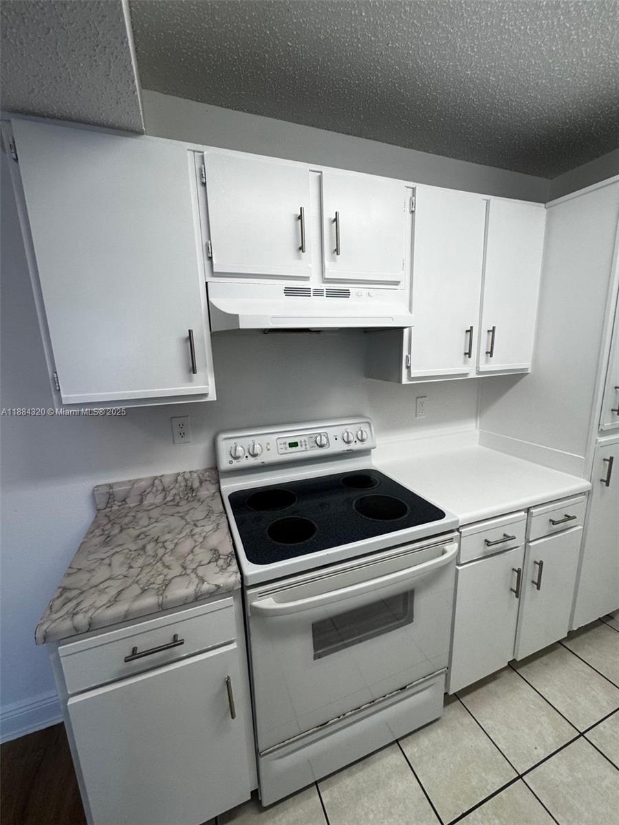 15040 Southwest 103rd Lane, Unit 3202 Miami, FL 33196 - Photo 7 of 14 a kitchen with granite countertop white cabinets and white appliances