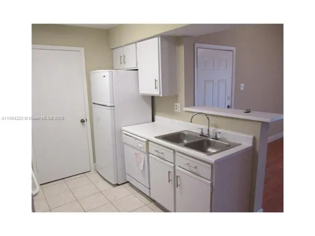 a kitchen with a sink cabinets and refrigerator