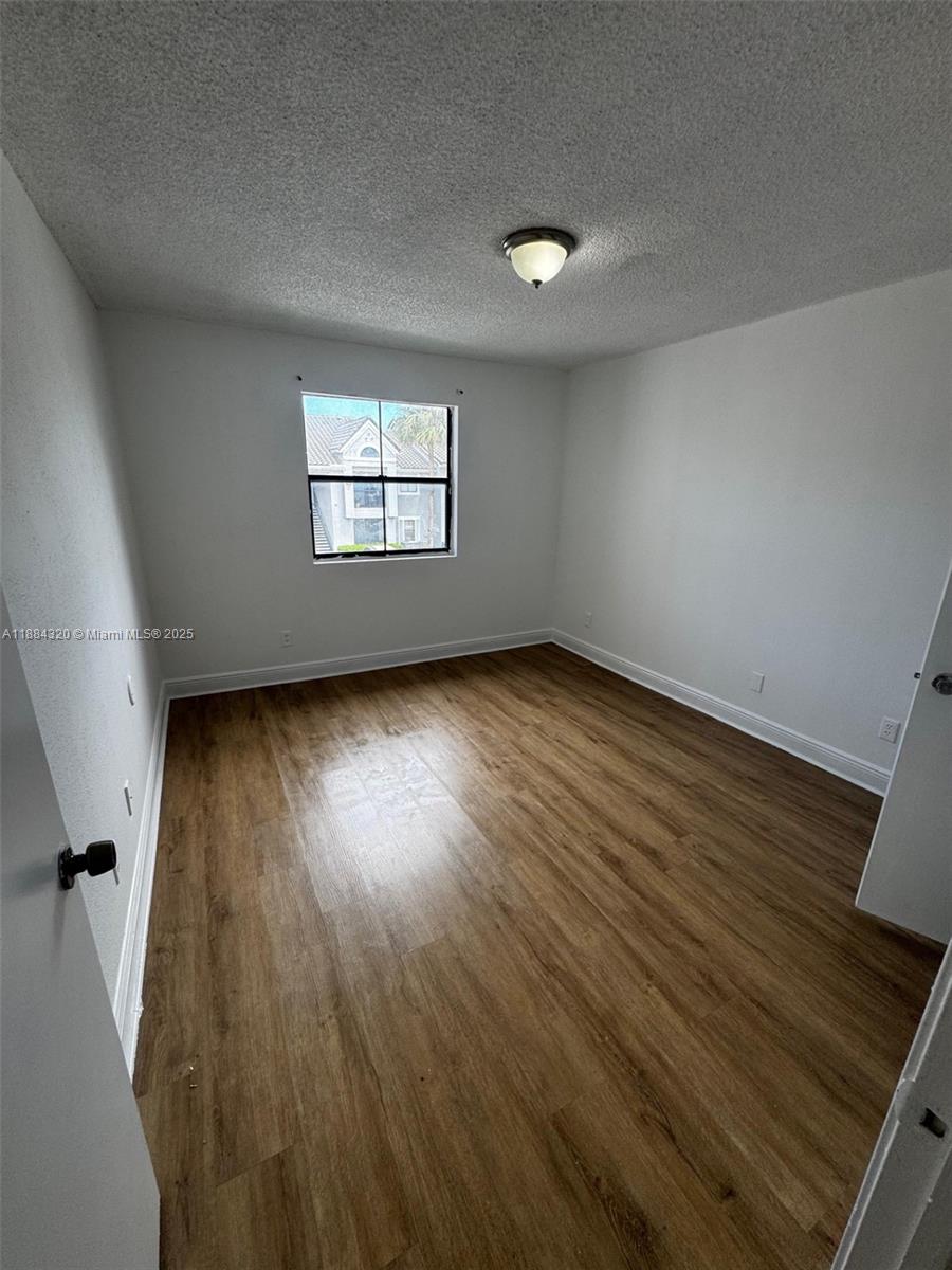 15040 Southwest 103rd Lane, Unit 3202 Miami, FL 33196 - Photo 10 of 14 an empty room with wooden floor and windows