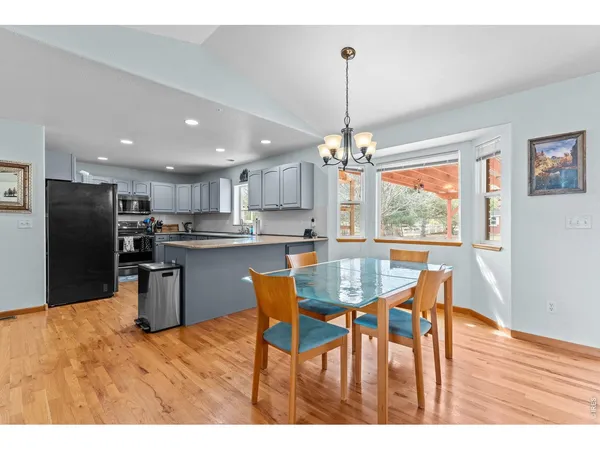 a view of a dining room and livingroom with furniture wooden floor a rug a flat screen tv
