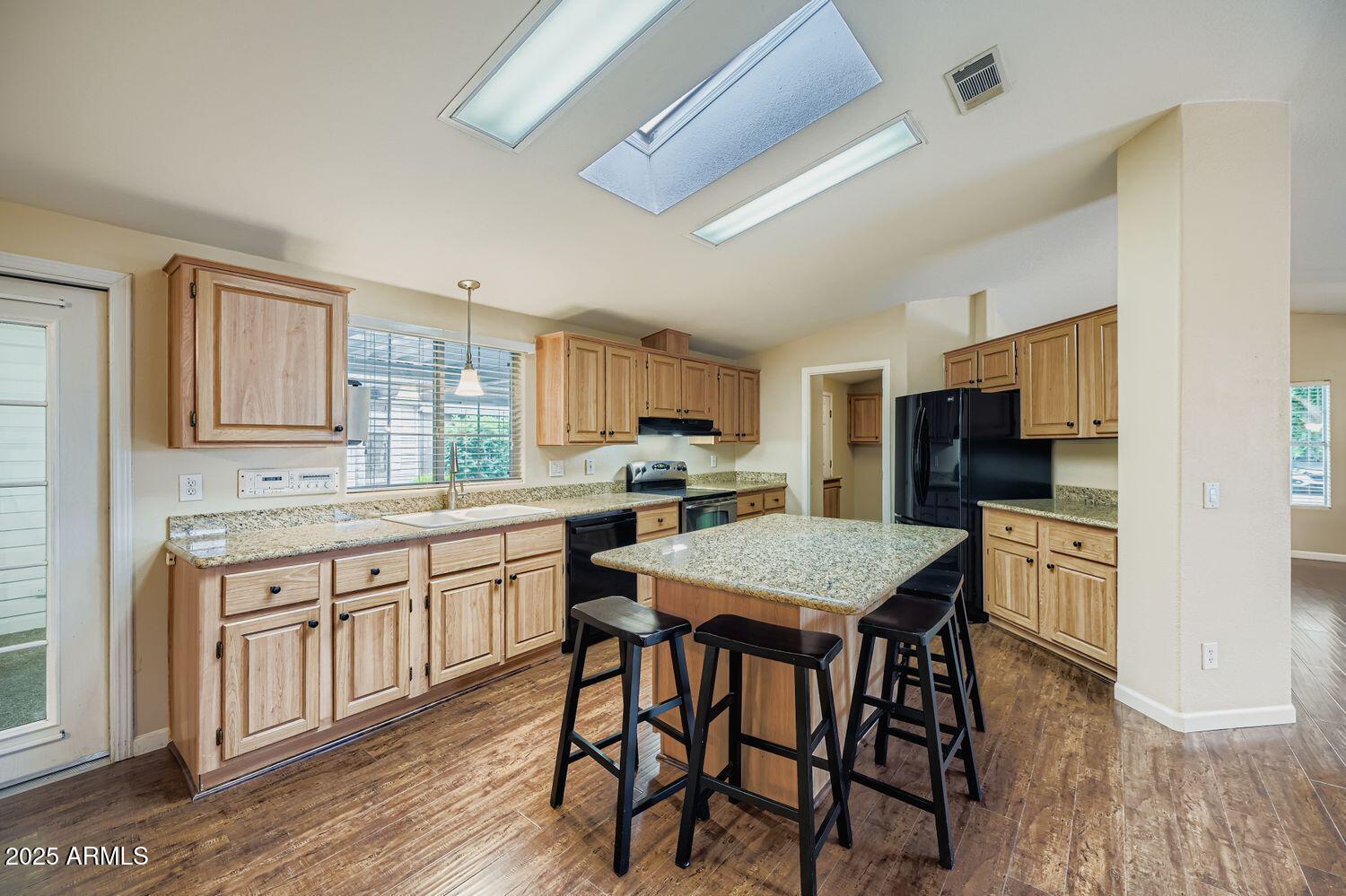 2550 South Ellsworth Road, Unit 277 Mesa, AZ 85209 - Photo 8 of 20 a kitchen with stainless steel appliances granite countertop a table chairs sink refrigerator and cabinets