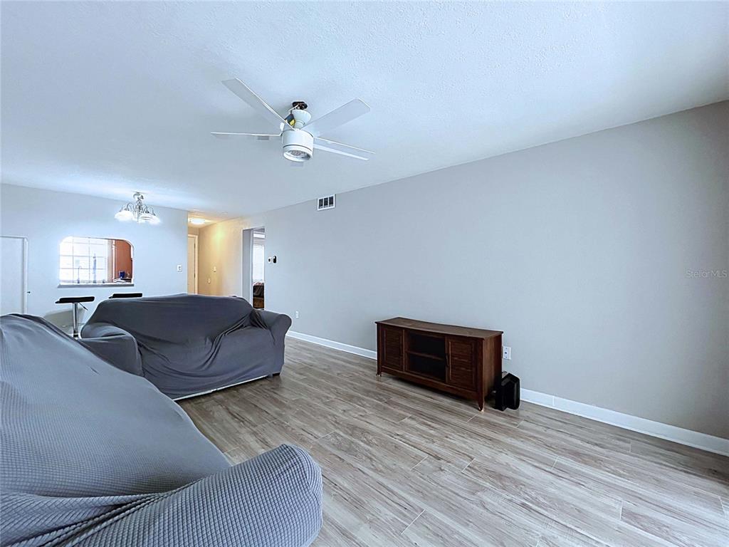 4227 Sheldon Place New Port Richey, FL 34652 - Photo 8 of 25 a spacious bedroom with a bed and a chandelier