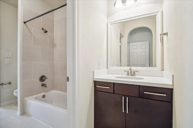 a bathroom with a tub sink and mirror