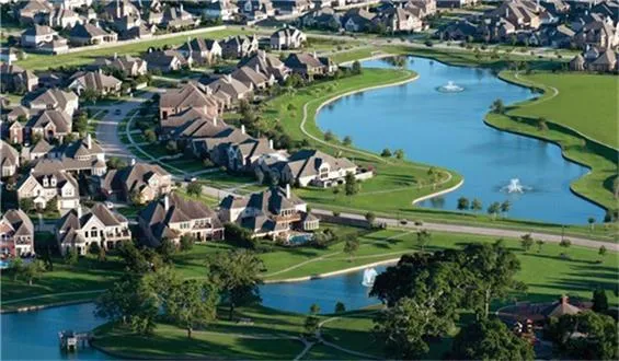 an aerial view of a house with a garden and lake view