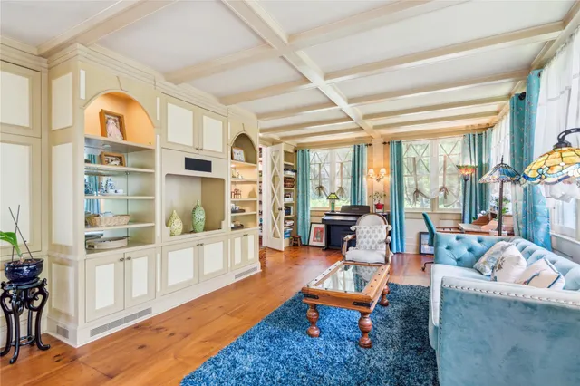 a living room with fireplace furniture and a large window