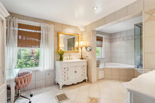 a bathroom with a tub a sink and mirror