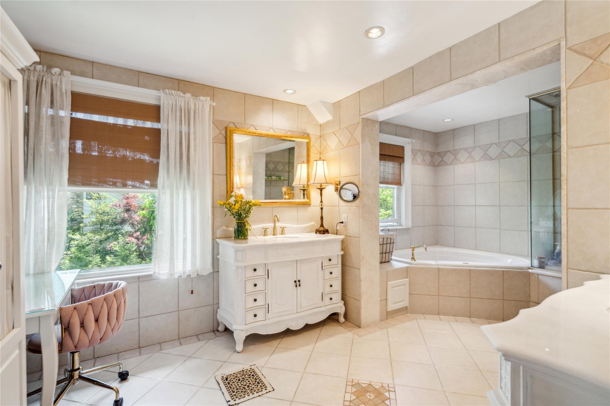 17 The Intervale Roslyn Estates, NY 11577 - Photo 19 of 33 a spacious bathroom with a tub sink and mirror
