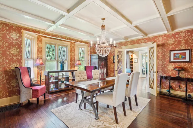 a dining room with wooden floor a chandelier a wooden table and chairs