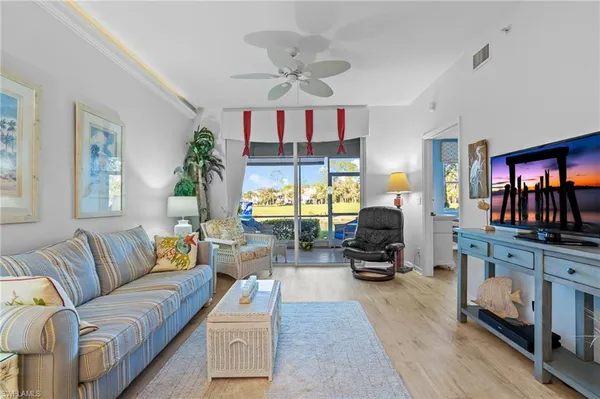 a living room with furniture ceiling fan and a window