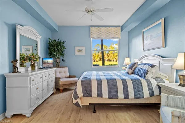 a bedroom with a bed and a potted plant on the dresser