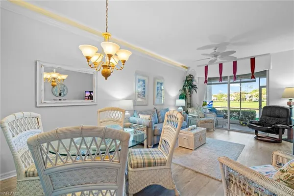 a living room with furniture chandelier and a window