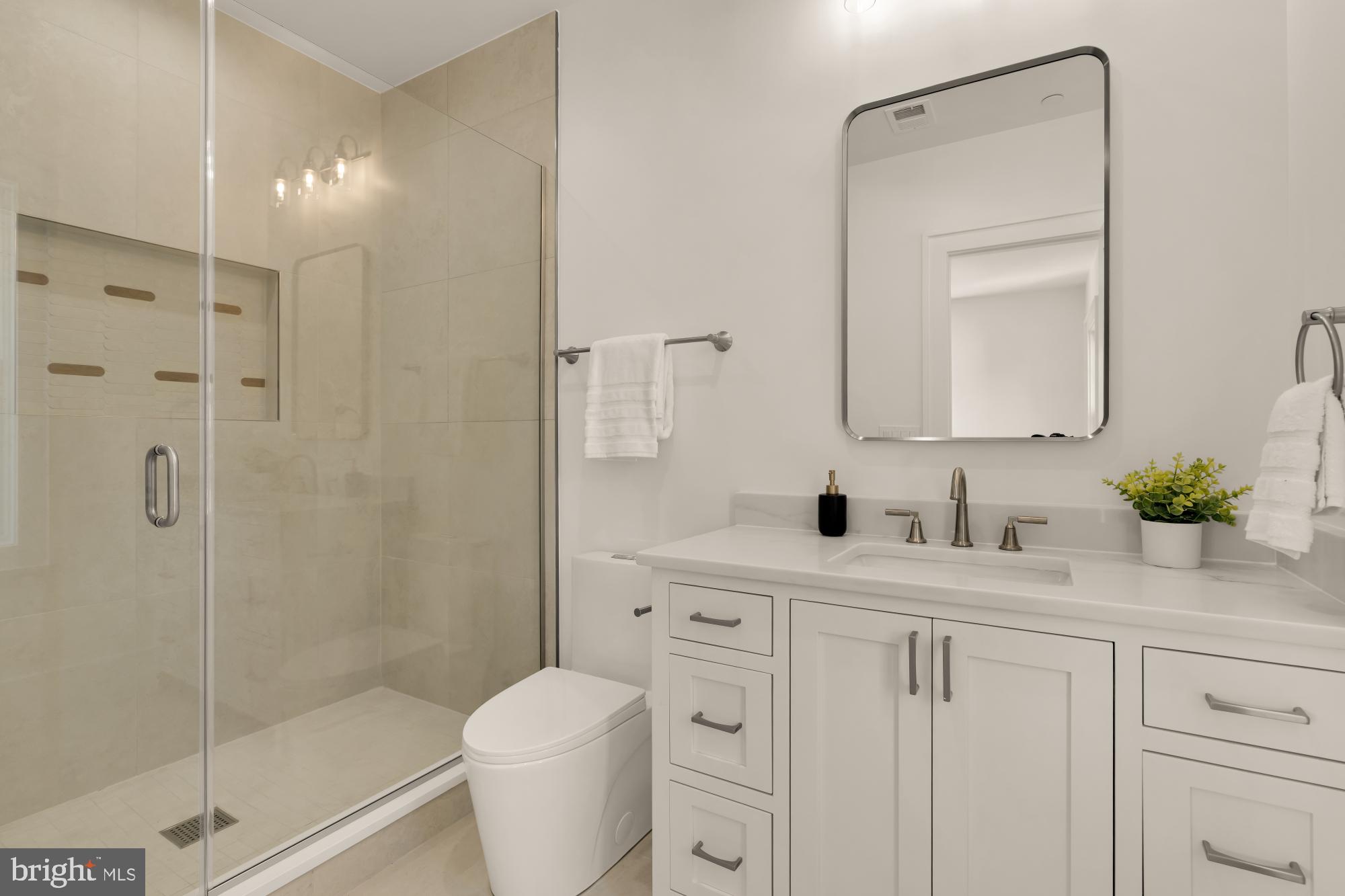 9105 Seven Locks Road Bethesda, MD 20817 - Photo 47 of 84 a bathroom with a granite countertop sink a toilet and a mirror