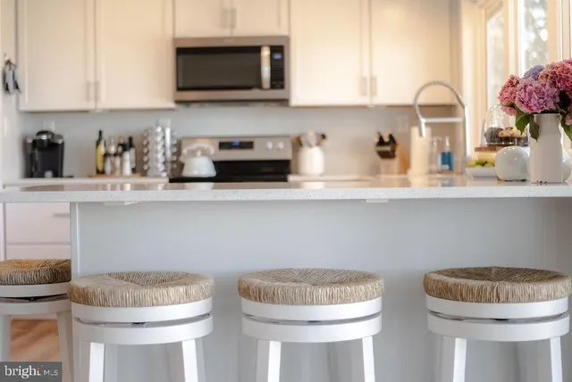 a kitchen with stainless steel appliances a white cabinets and a wooden floor