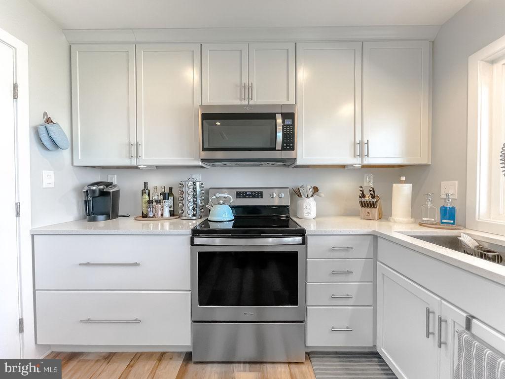 18375 River Road Tall Timbers, MD 20690 - Photo 14 of 61 a kitchen with stainless steel appliances granite countertop a stove and white cabinets