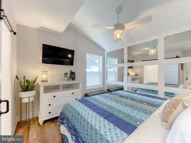 a spacious bedroom with a large bed and a flat screen tv