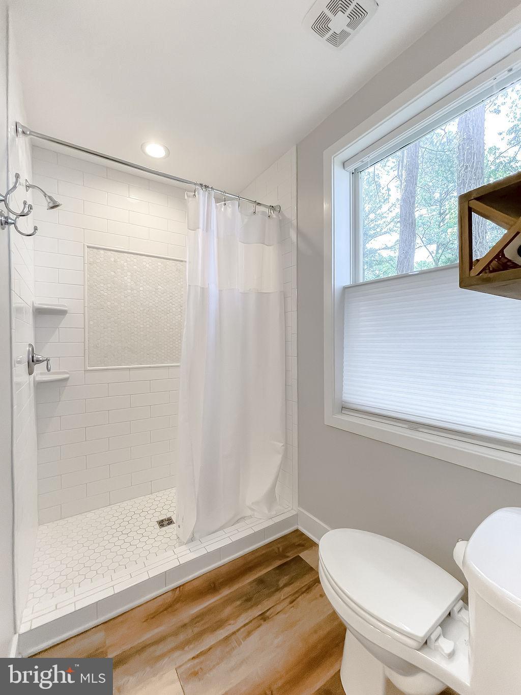 18375 River Road Tall Timbers, MD 20690 - Photo 26 of 61 a bathroom with a shower a toilet and a window
