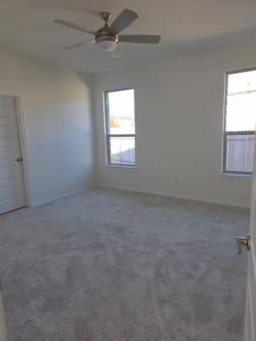 an empty room with a window and a fan