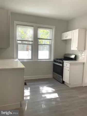 a kitchen with granite countertop a stove a sink and a window