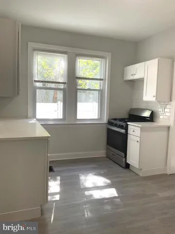 a kitchen with granite countertop a stove a sink and a window