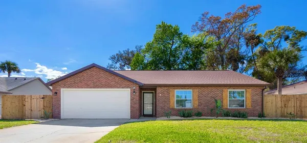 a view of a brick house with a yard