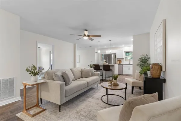 a living room with furniture kitchen view and a potted plant
