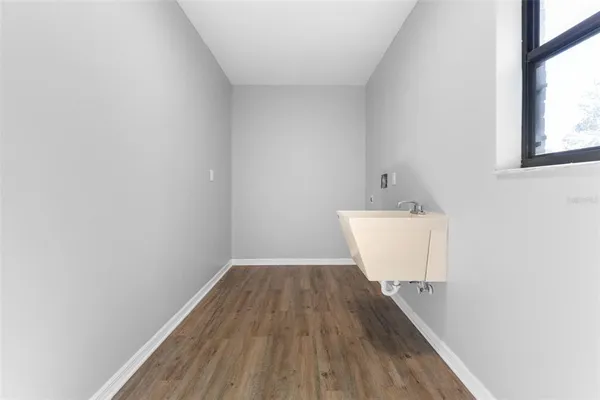 a view of a room with wooden floor and a sink