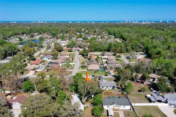 an aerial view of residential houses with outdoor space and trees