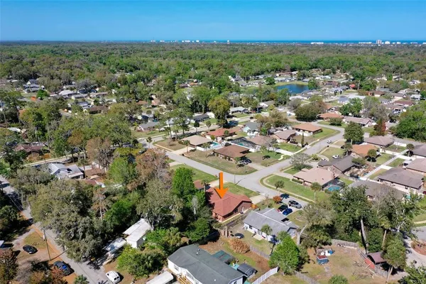 an aerial view of residential houses with outdoor space and trees