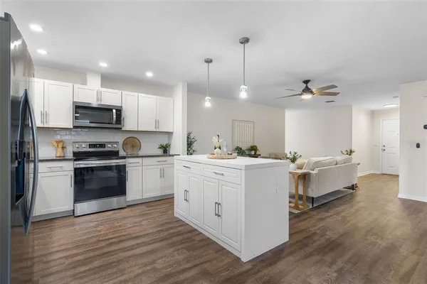 a kitchen with kitchen island granite countertop a white stove top oven and cabinets