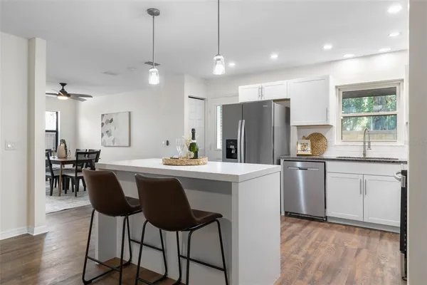 a kitchen with refrigerator a sink and chairs