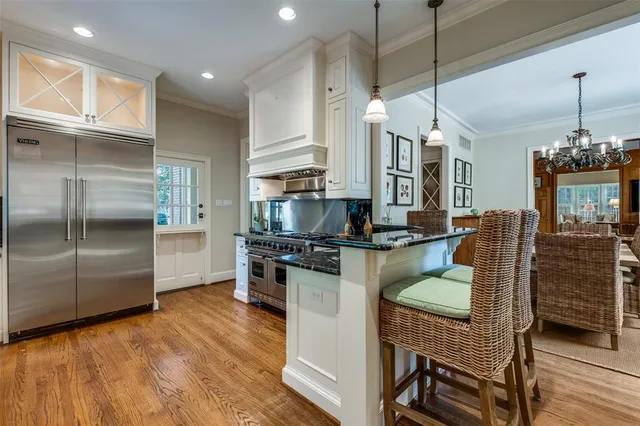 a kitchen with a refrigerator a stove and a wooden floor