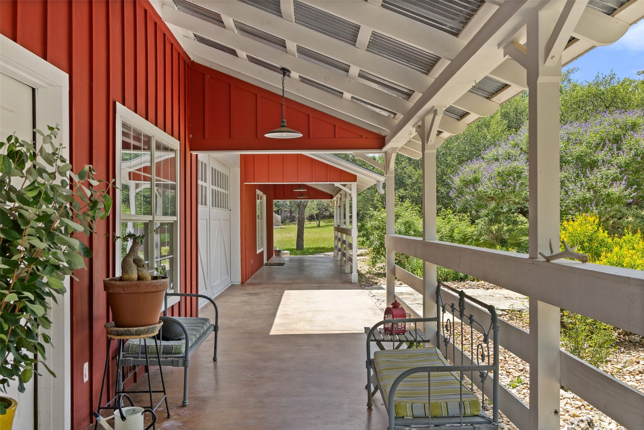 505 Red Corral Ranch Road Wimberley, TX 78676 - Photo 38 of 40 A lengthy covered porch offers a serene outdoor space, overlooking the natural landscape.