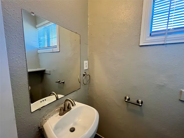 a bathroom with a sink mirror and toilet