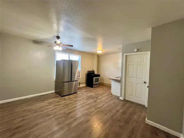 a view of a kitchen with a sink and a refrigerator