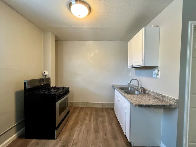 a kitchen with a sink stove and cabinets