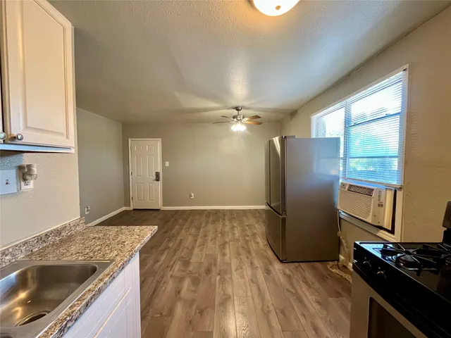 a kitchen with granite countertop a refrigerator and a stove