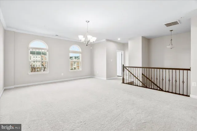 en empty room with stairs and wooden floor